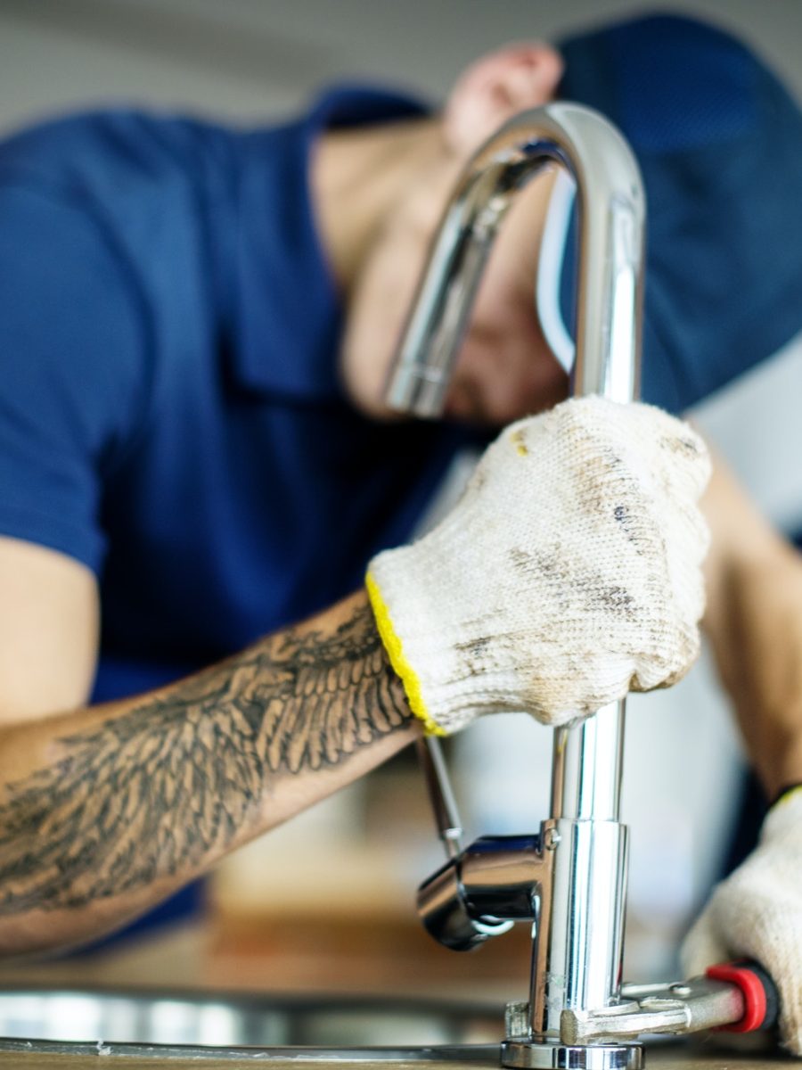 Plumber fixing kitchen sink